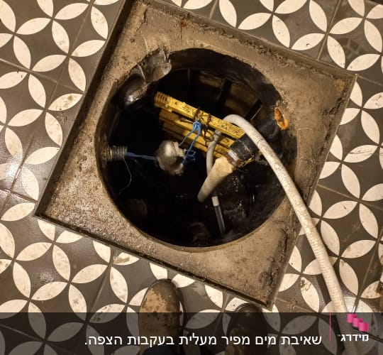 צינור לבן מחובר לפתח ביוב עגול